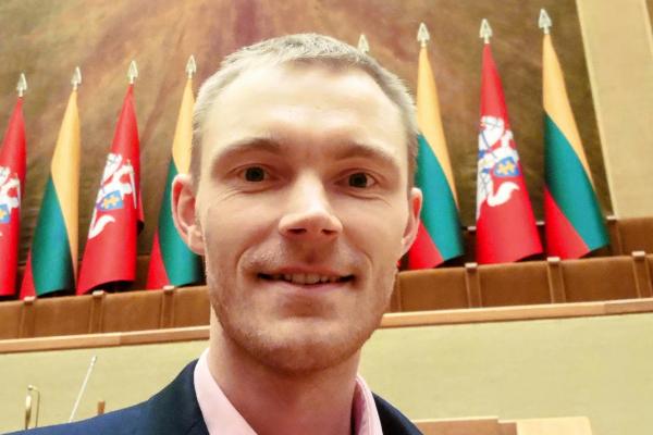blond hair man with flags in the background